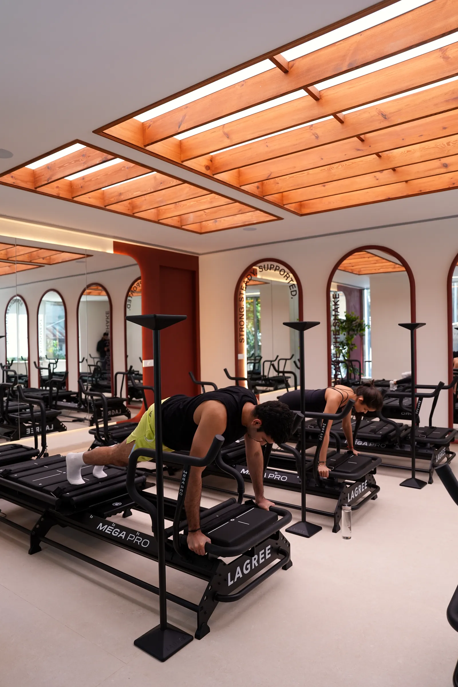 Clients mid-workout on Megaformers under the studio skylight